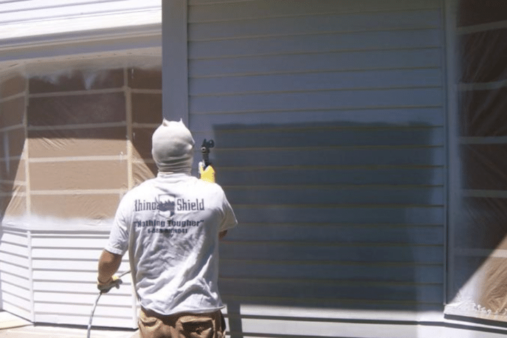 Professional painters apply rhino shield exterior coating to home.